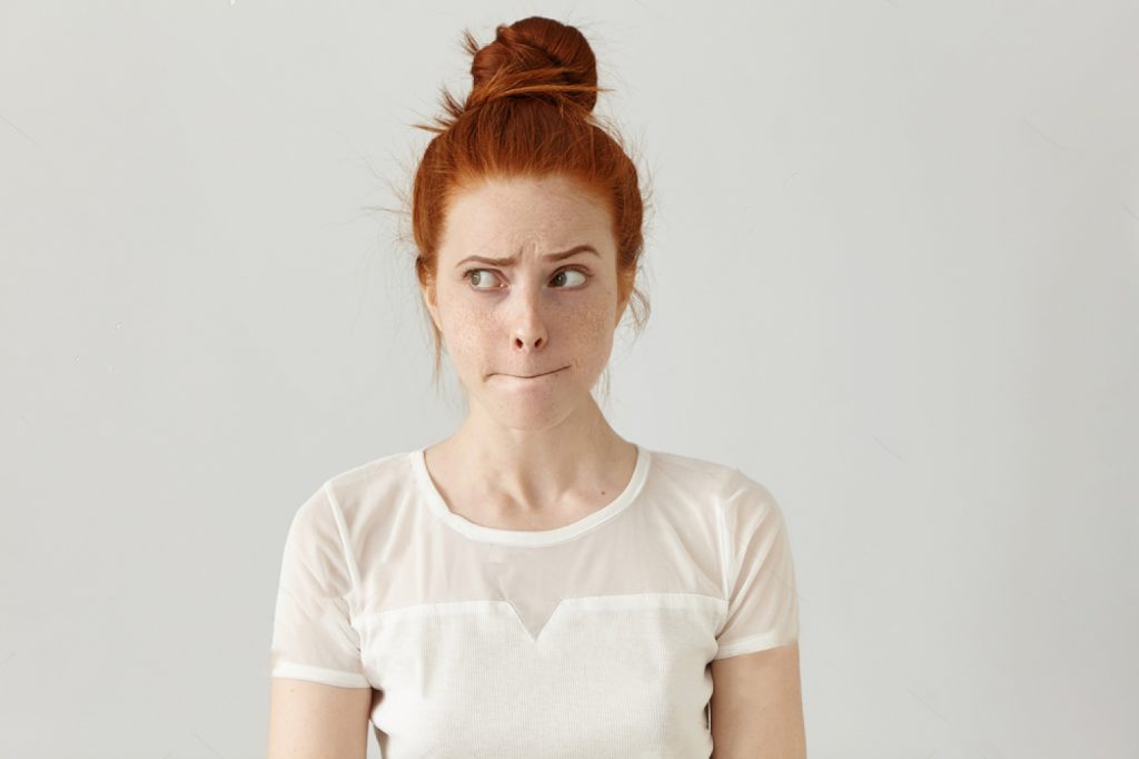 confusion questionnement jeune femme rousse
