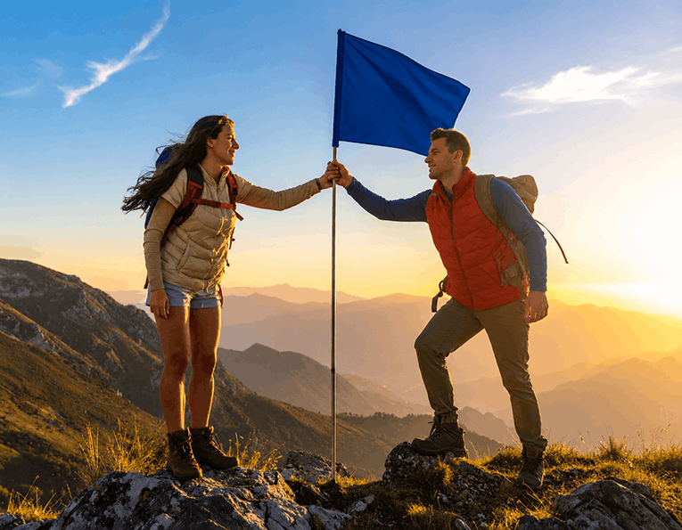 couple au sommet d'une montagne atteignant l'objectif de missions des flammes jumelles